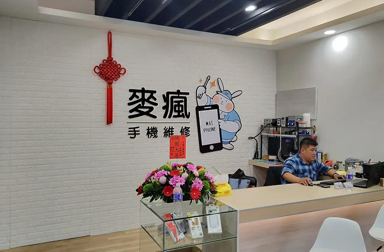 麥瘋手機維修店內櫃台，後方牆面有logo圖案